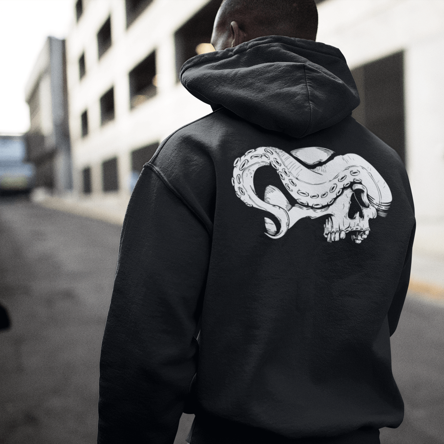 Man's back wearing zip up skull hoodie with skull and tentacle print
