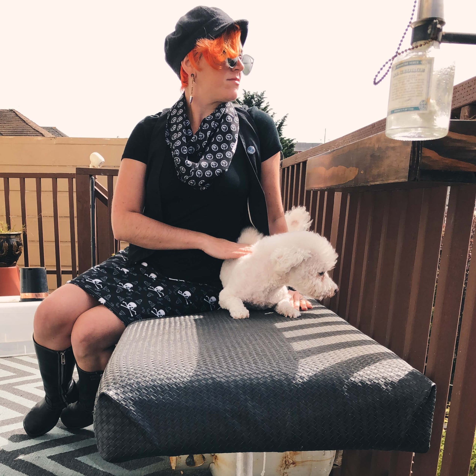 Woman with orange hair and hat with dog wearing skull and crossbones skirt
