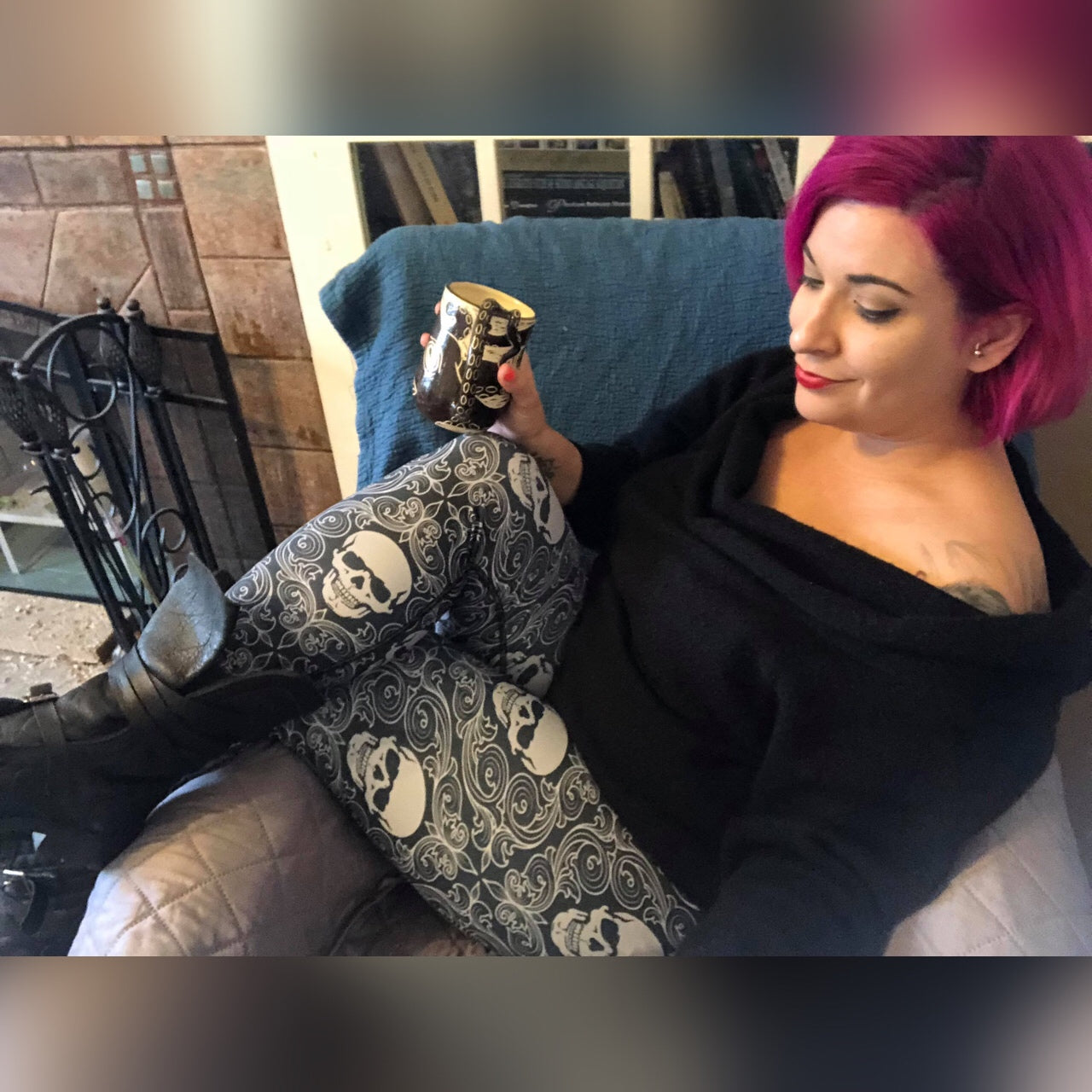 Woman with purple hair wearing skull print yoga leggings holding coffee