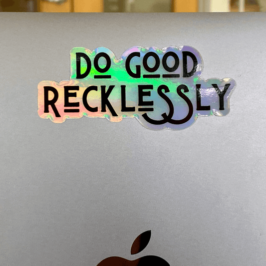 Holographic "do good recklessly" stick on silver laptop