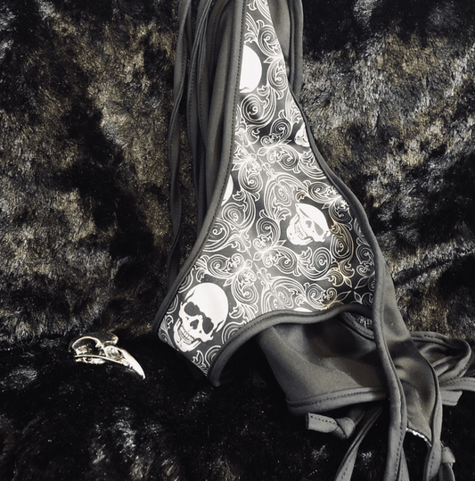 skeleton wallpaper bikini hanging near a metal bird skull on a black background