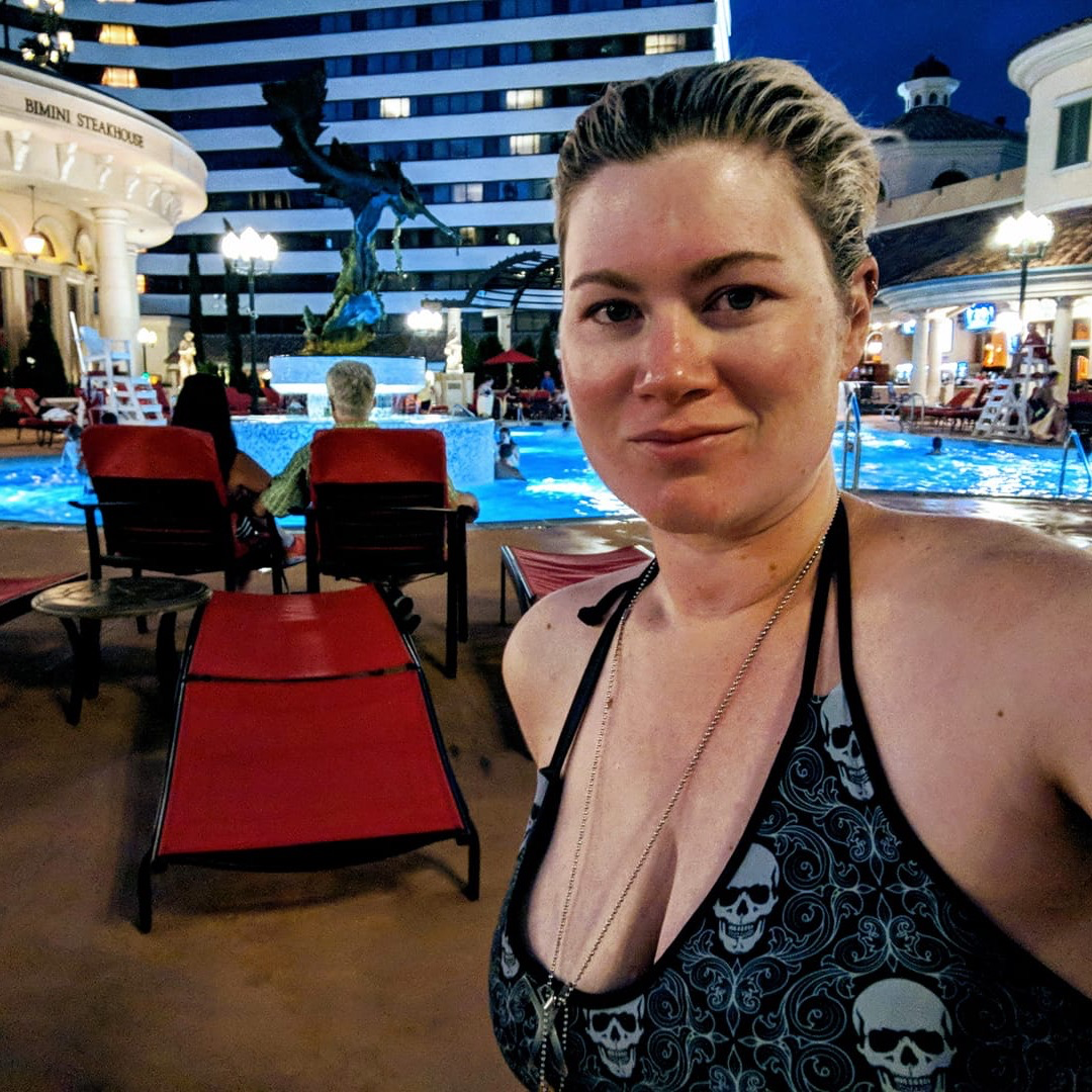 blonde woman with skeleton wallpaper bikini top at a las vegas hotel pool
