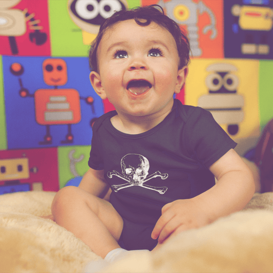 Baby smiling wearing skull and crossbones onesie in black
