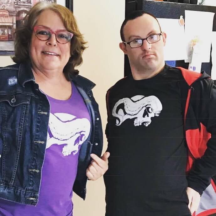 Woman and young man wearing purple and black skull and tentacle shirts with jackets