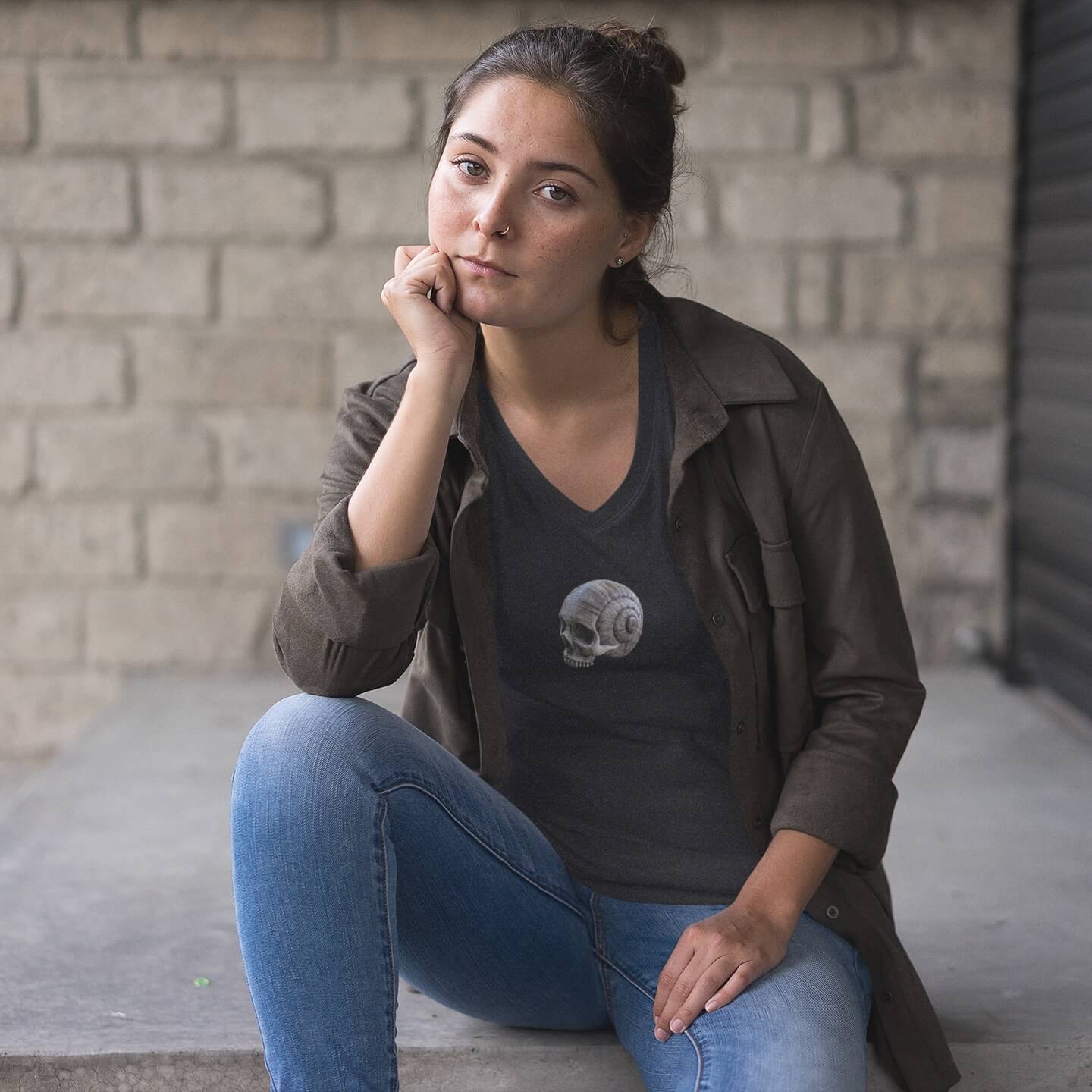 Woman sitting in jeans and spiral skull print v-neck t-shirt